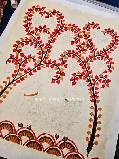 The early stages of a large Kalamkari painting, with the red and orange leaves being filled in while the central figures are still just pencil sketches.