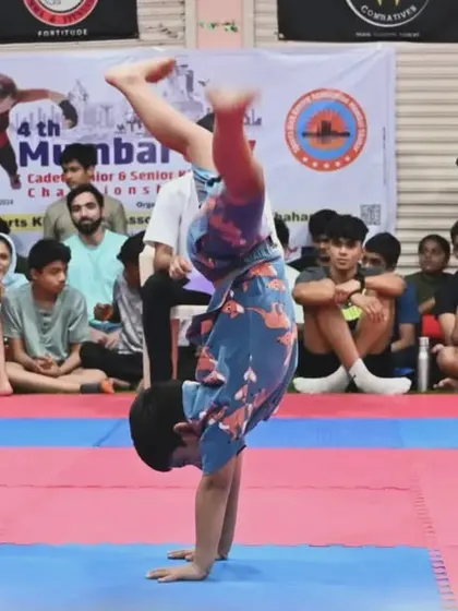 A student performs a creative form during a competition, showcasing the athletic and artistic side of martial arts. We encourage creativity alongside discipline.
