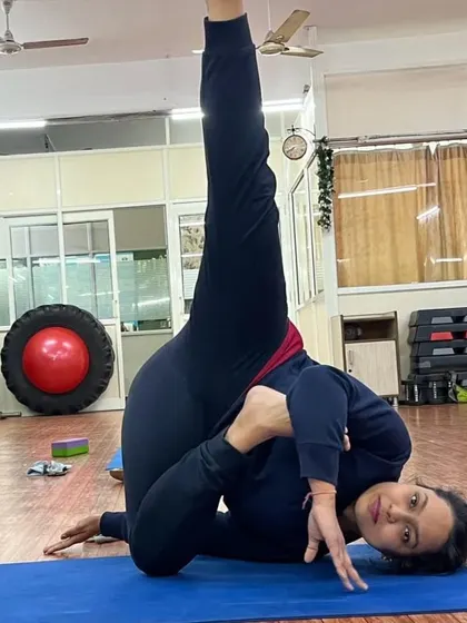 A student demonstrating an advanced twisting and balancing pose. This requires a combination of deep flexibility, core strength, and intense focus.