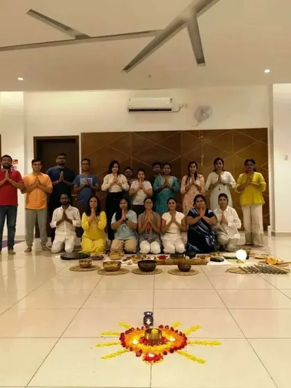 A group photo from a breathwork and sound healing session, with a beautiful flower mandala adding to the serene and spiritual ambiance.