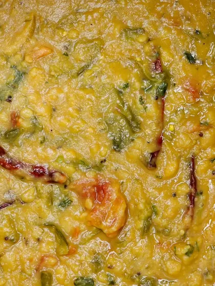 A thick and hearty dal, cooked with vegetables and tempered with spices, a nutritious and flavorful main course.
