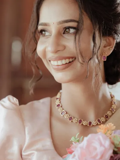 A radiant Christian bride, her smile lighting up her face as she holds a bouquet of flowers.