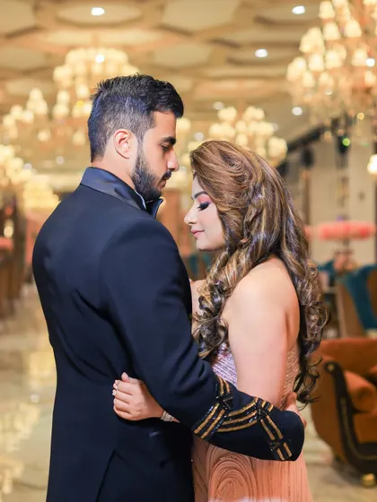 An intimate and romantic portrait of the couple before their reception. The warm lighting and their close embrace create a beautiful, moody photograph.
