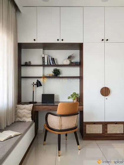 This inviting workspace features a built-in desk, open shelving, and a comfortable chair. The window seat next to it provides a lovely spot to take a break.