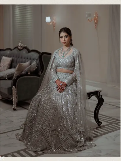 A regal portrait of the bride seated, looking poised and graceful in her Sangeet attire.