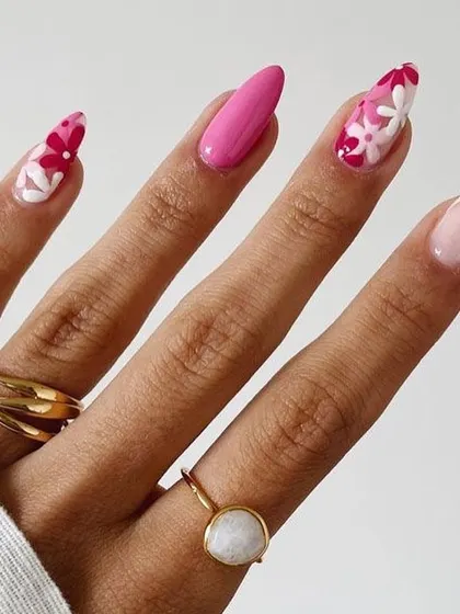 A beautiful floral manicure perfect for summer. This design features a mix of solid bright pink nails and accent nails with a '70s-inspired floral pattern in shades of pink and red.