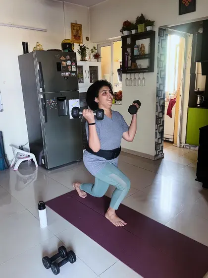 A client performs dumbbell lunges, a core part of our strength program. This exercise is excellent for building lower body strength, improving balance, and boosting metabolism.