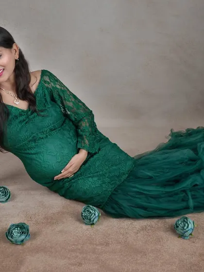 A serene moment on the floor, this pose beautifully showcases the full lace and tulle detail of our popular emerald green gown.