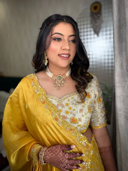 A three-quarter shot of the client, her hand with mehendi visible, complementing her traditional yet fresh look.