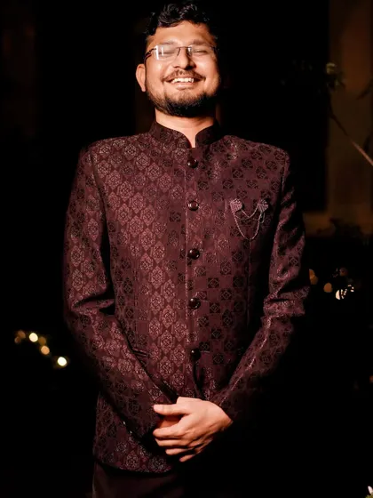 A portrait of the groom looking happy and dapper in his reception attire.