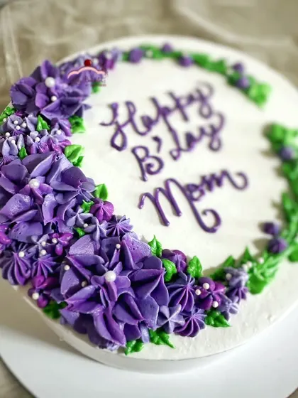 A crescent of beautiful purple buttercream blossoms for a mom's birthday. This was a delicious lemon and blueberry cake.