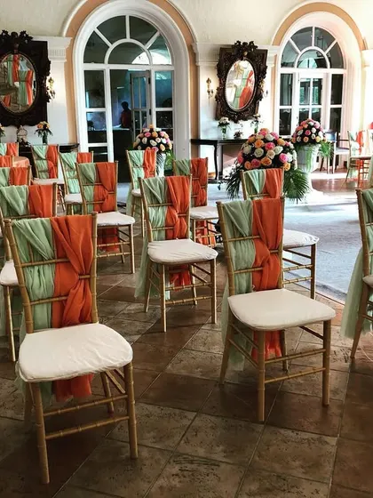 It's all in the details. For this event, we decorated the Chiavari chairs with dual-colored drapes in orange and mint green, adding a unique and colorful touch to the guest seating.