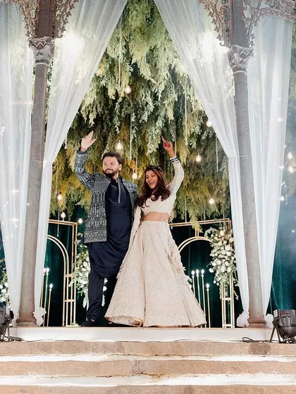 The couple makes a grand entrance onto their Sangeet stage, complete with cold pyro fireworks for a dramatic effect.