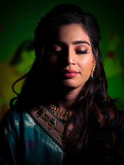 A simple, elegant portrait of the bride during her ring ceremony. The dark, moody lighting with a pop of green in the background makes her features and expression stand out beautifully.