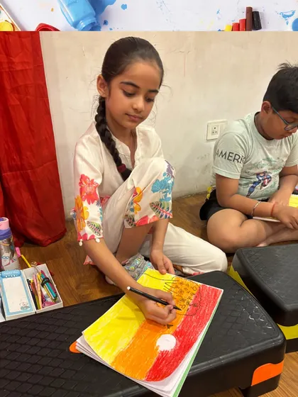 A student is focused on creating a colorful sunset drawing. Art is a wonderful way for children to practice concentration and patience.