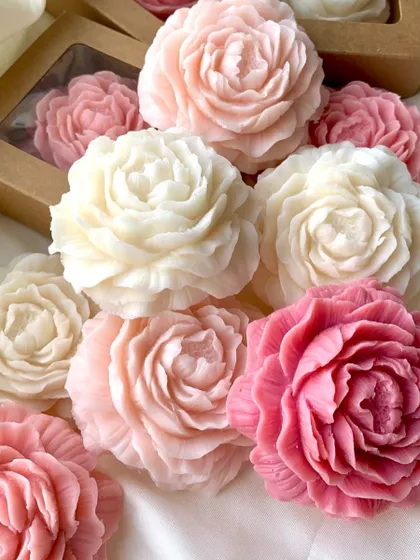 A beautiful assortment of peony candles in various shades of pink and white. I can customize the colors to match your theme.