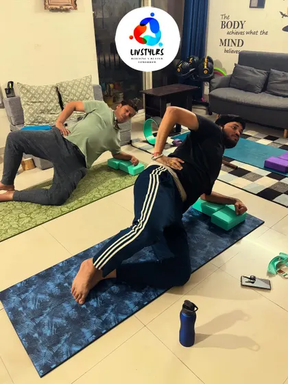 Two clients practice a side plank variation, building core strength and stability.