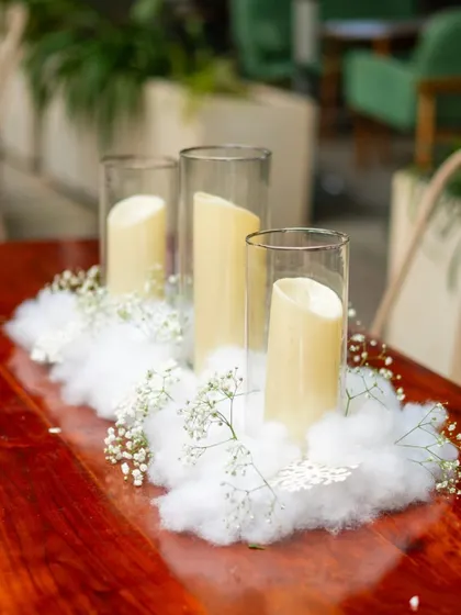 A beautiful centerpiece for the Frozen-themed party, featuring pillar candles nestled in a bed of soft cotton "snow" and delicate baby's breath.
