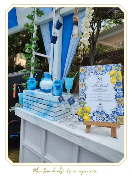 A Mediterranean-themed mocktail bar, featuring blue and white tiling, lemon motifs, and fresh greenery. This setup is perfect for a refreshing and stylish daytime event.
