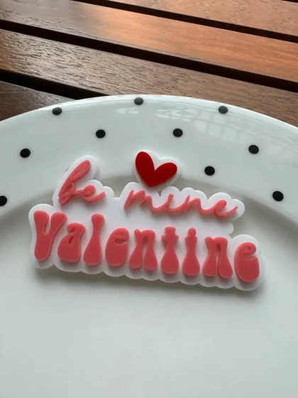 "Be mine Valentine." A sweet and romantic layered acrylic charm to adorn your Valentine's Day desserts.