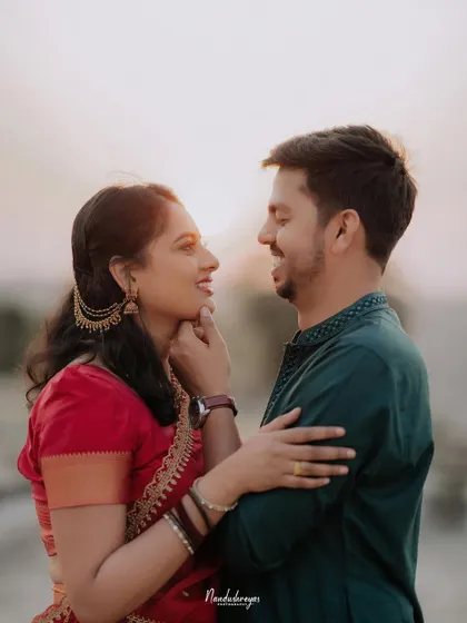 A sweet moment captured as the bride gently touches the groom's chin, their expressions full of affection.