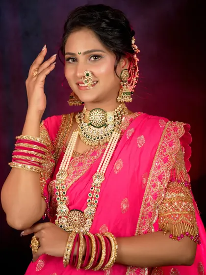 A full-length portrait of the bride in her beautiful pink saree, adorned with heavy traditional jewelry. She looks radiant and confident, the epitome of a Maharashtrian bride.