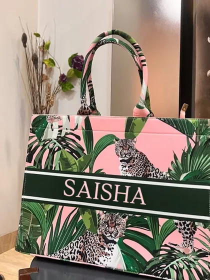 This pink and green leopard print suede tote bag is fierce and fabulous. It's personalised with the name 'Saisha' in a bold font.