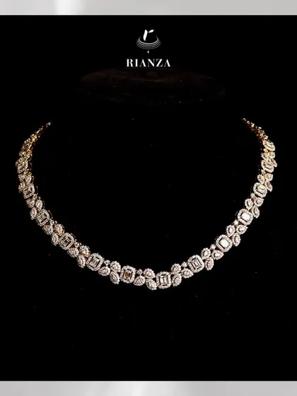 This collar-bone necklace features a stunning array of emerald-cut solitaires, each framed by marquise and pear-shaped diamonds. It is a modern take on classic bridal luxury.