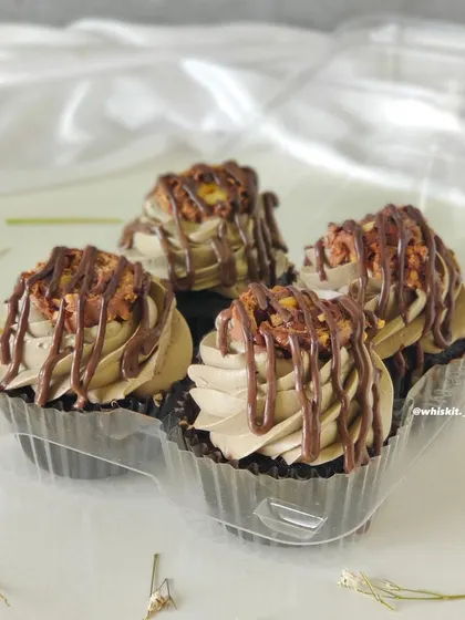 A close-up of my Ferrero Rocher cupcakes, showing the rich chocolate frosting, crunchy hazelnut topping, and Nutella drizzle.