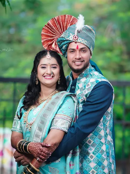 A classic wedding portrait of the couple looking directly at the camera. Their happy smiles and traditional Maharashtrian attire make for a perfect family photograph.