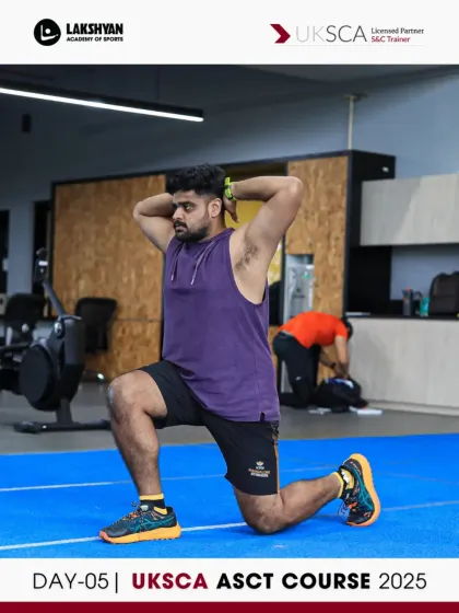 A coach performs a lunge with overhead hold, an exercise that challenges stability and mobility, as part of the Day 5 practicals.