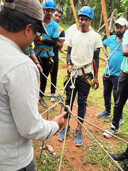 An instructor provides one-on-one guidance during a practical knot-tying lesson.