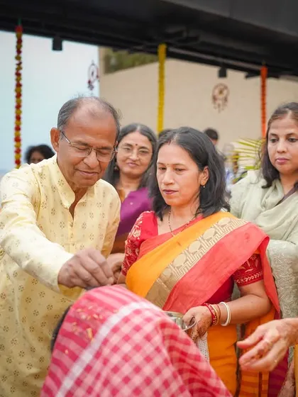 A candid moment from a traditional family ceremony. This photo captures the elders performing a ritual, surrounded by family, showcasing the importance of blessings and togetherness in our culture.