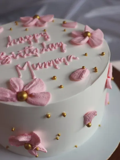 A sweet and simple cake for a mom's birthday, with pink piped flowers and gold bead accents.