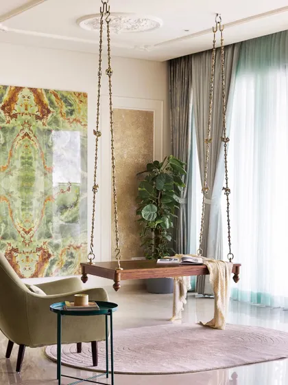 A wider view of the living area, showcasing the traditional swing, the elegant armchair, and the stunning custom tile installation.