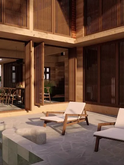 The poolside patio of a Morjim villa, demonstrating the seamless connection between the interior and exterior. Folding doors open up the living area to the stone deck and plunge pool, perfect for enjoying Goa's tropical climate.