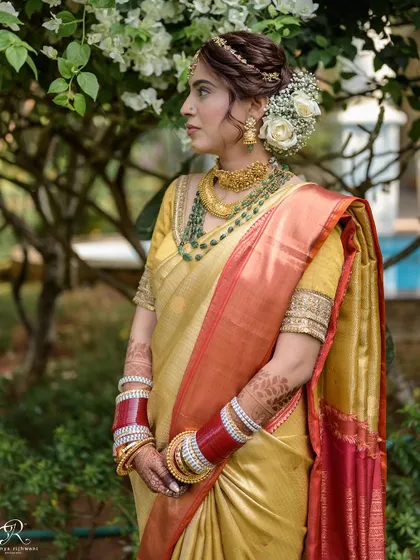 A stunning portrait of a South Indian bride, showcasing her beautiful silk saree and floral hair arrangement.