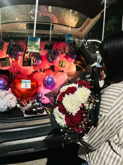 The combination of balloons, photos, and flowers makes for a truly personal and memorable car trunk surprise.