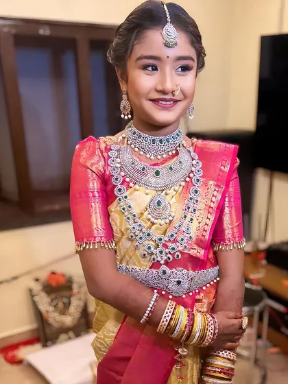 A beautiful young lady celebrating her puberty ceremony in our full American Diamond and emerald jewellery set. Our collection is perfect for all milestone events.