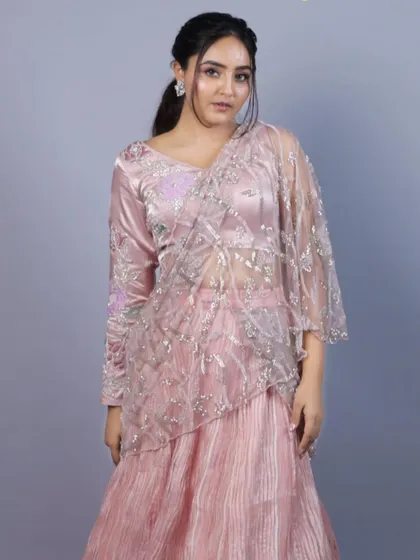 A full view of the baby pink Indo-Western saree from our 'Yuthika' collection. The outfit combines a pleated skirt with a pre-draped, embroidered net pallu for a modern and hassle-free take on the classic saree.
