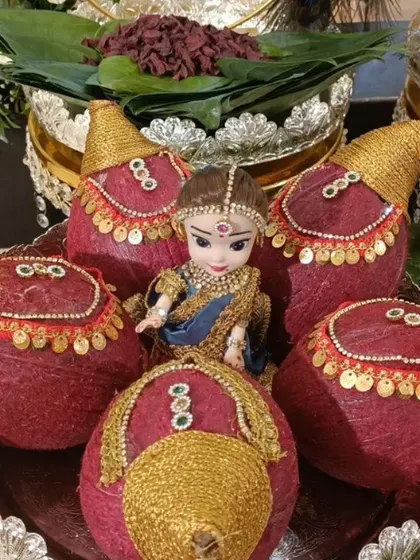 A close-up of decorated coconuts with a small doll for a seemantham in Nagarbhavi. These traditional elements are central to the ceremony.