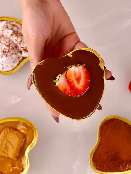 A close up of the Belgian Chocolate Fresh Berry Mousse, served in a heart shaped dish and topped with a fresh strawberry.