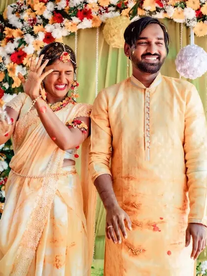 A fun action shot from a Haldi ceremony, capturing the splash of water and the couple's hilarious reaction. These are the moments you'll always remember.