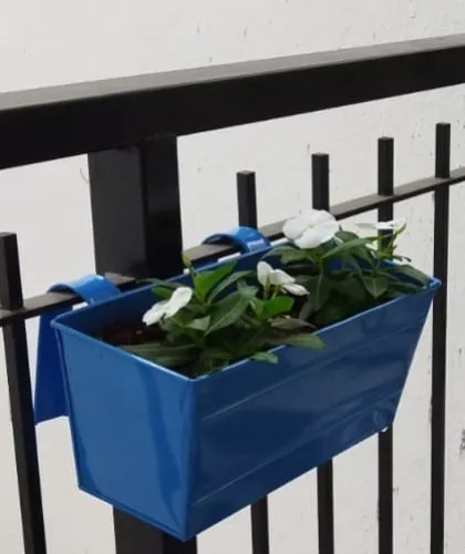 A close-up of the metal railing planter with white Vinca flowers, a simple and effective way to add plants without using floor space.