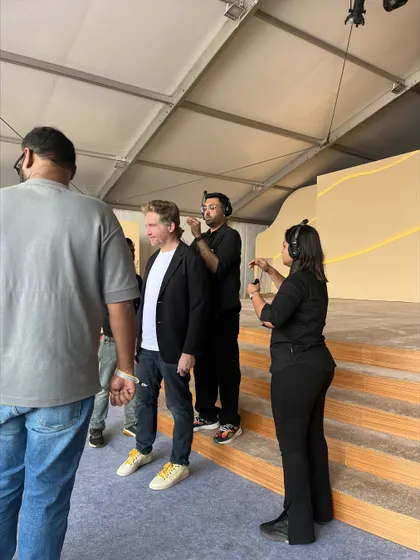Our team fitting a speaker with a microphone and earpiece backstage at the TATA Sierra event. We ensure all talent is properly equipped before going on stage.
