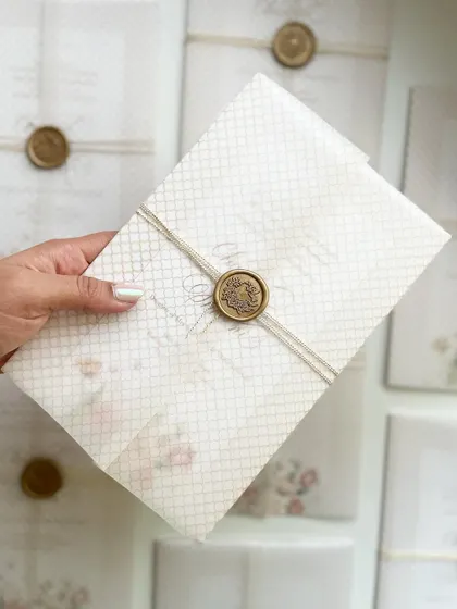 Holding my sister's wedding invitation. It was a true labor of love, from the hand-painted floral design to the calligraphy and assembly.