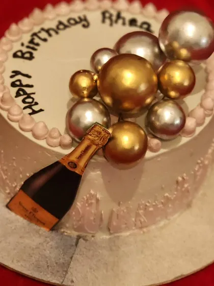 Here is another view of the champagne-themed cake, showing the personalized "Happy Birthday Rhea" message. I can add any name or message to make your celebration cake unique.