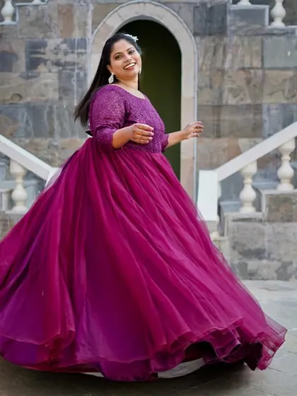 A joyful, twirling shot of a bride in a magnificent purple gown, capturing the movement and happiness.