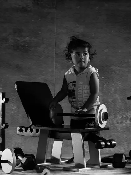 A dramatic black and white shot of a toddler in the gym, creating a powerful and artistic look.