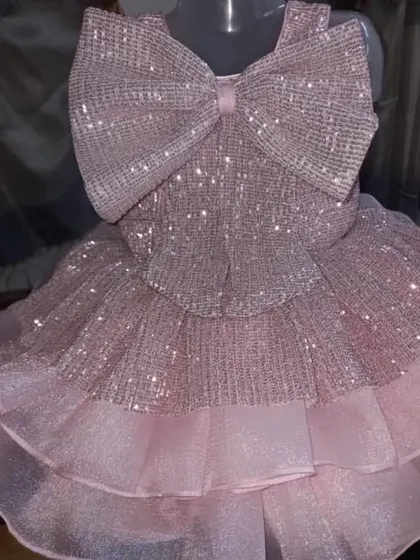 A very sparkly baby pink frock with a huge sequined bow on the front.
